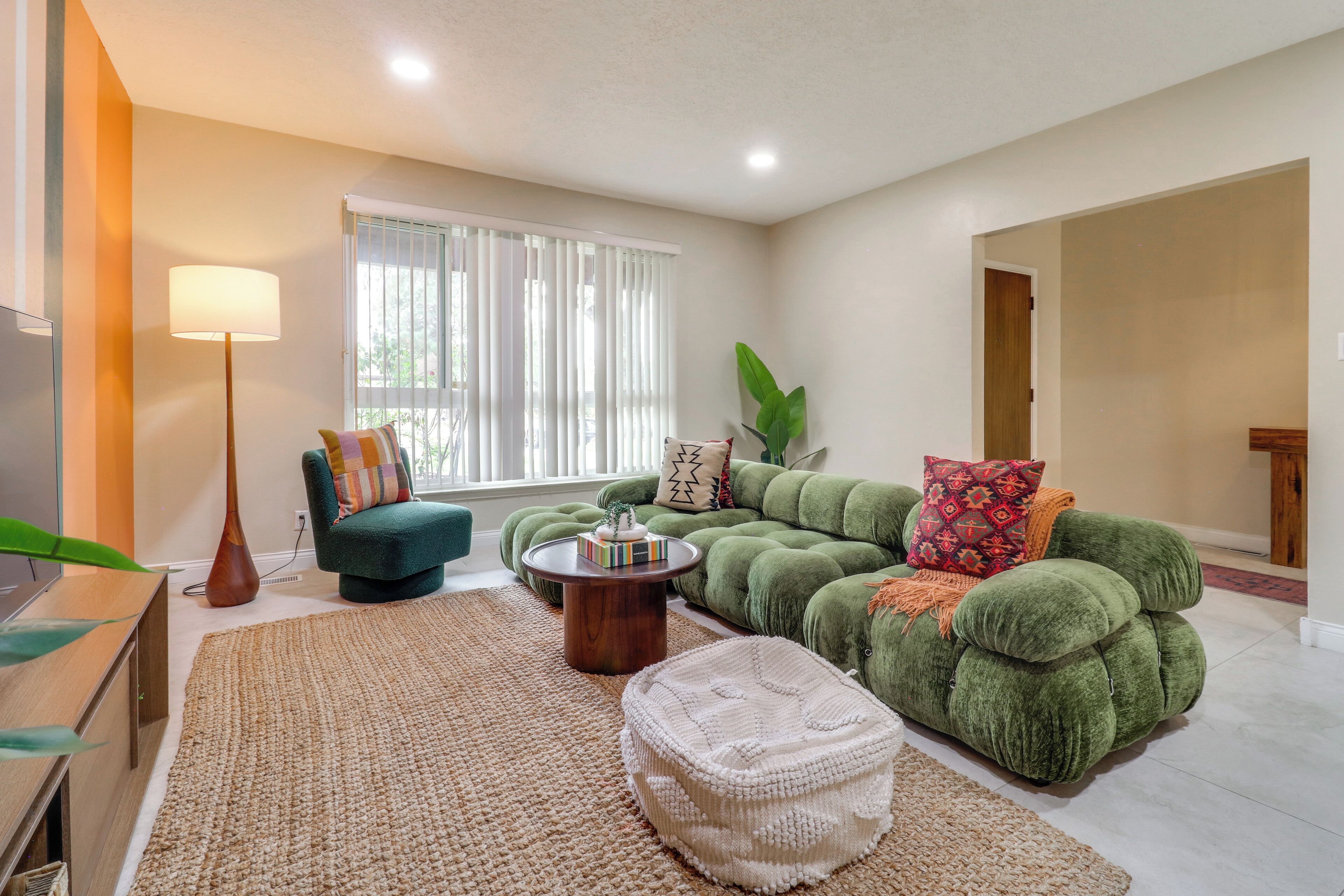 A living room with a green sofa, a round coffee table, and a television.