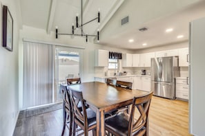 Una cocina moderna con una isla grande, electrodomésticos de acero inoxidable y un comedor con sillas de madera.