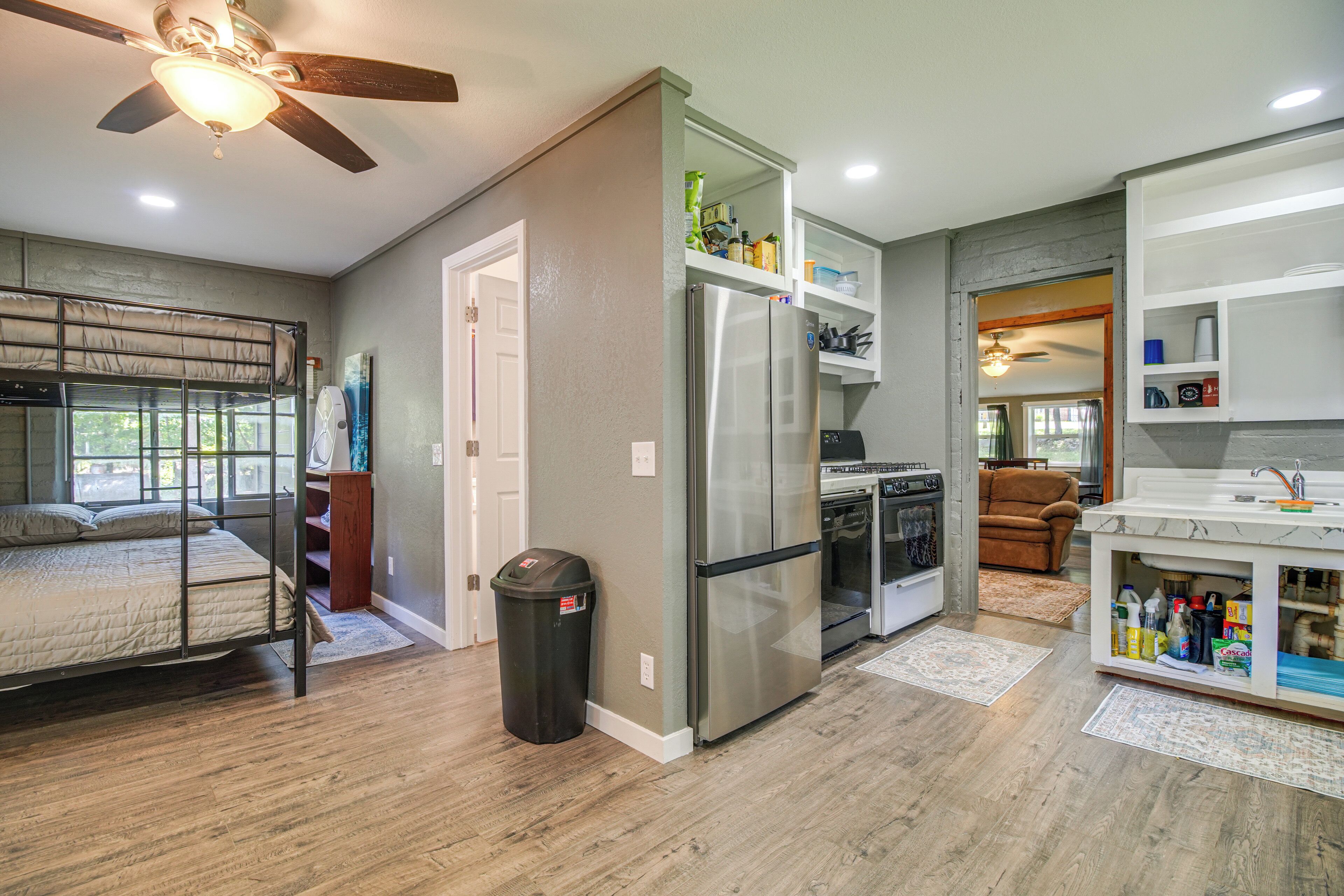 A compact kitchen with a refrigerator, oven, and a dining area with a sofa.
