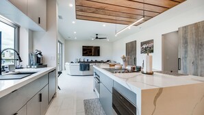 A modern kitchen with a large island, built-in appliances, and a view to the living area. - Trackside Luxury at Atlanta Motorsports Park (Dawsonville)