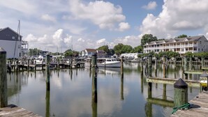 A marina with docked boats, wooden piers, and residential buildings in the background. - Walk to Cambridge Waterfront: Townhome w/ Deck (Cambridge)