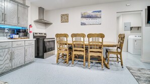 A modern kitchen with a dining table, cabinets, and appliances. - Family Fun! Quaint Seminole Home w/ Grill & Patio (Seminole)
