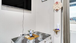 A bathroom with a marble vanity, a clock, a small shelf with toiletries, and a window with a view of the beach. - Family Fun! Quaint Seminole Home w/ Grill & Patio (Seminole)