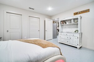 Un dormitorio con una cama, un aparador y dos puertas.