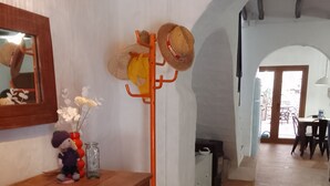 Quarto com um armário de madeira, um porta-chapéus, um espelho e vista para o exterior.