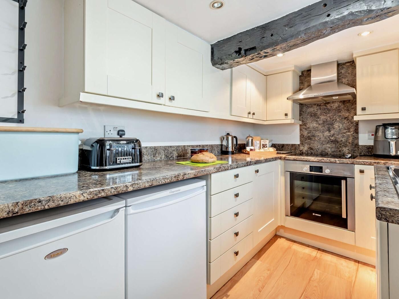 A modern kitchen with white cabinets, a Bosch oven, and a toaster.