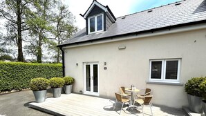 En bygning med terrasse, dør og vindue.