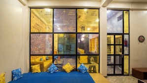 A room with a large bed, a dartboard, and a window with travel-themed decorations.