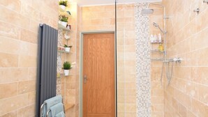 A shower area with a glass door, a wooden door, and a tiled wall. - 1 Bed in Lymington (oc-50723) (Sway)