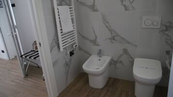 Ein Badezimmer mit einer Bio-Toilette, Toilette und Handtuchhalter.