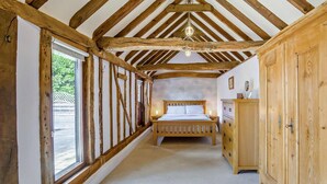 A bedroom with a wooden ceiling, a bed, a dresser, and a window. - 1 Bed in Dunmow (oc-51222) (Thaxted)