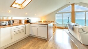 A modern kitchen with a skylight, a dining area with a view, and a cozy seating area. - 2 Bed in Torquay (oc-51143) (Torquay)