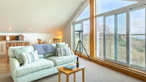 A spacious loft with a large window, a cozy seating area, and a kitchen. - 2 Bed in Torquay (oc-51143) (Torquay)