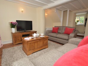 A living room with a TV, wooden cabinet, and a sofa with red cushions. - 1 Bed in Sherborne (oc-51018) (Thornford)