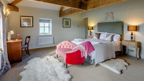 Ein Schlafzimmer mit Bett, Stuhl, Schreibtisch, Fenster und Heizkörper.