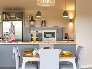 A modern kitchen with grey cabinets, a central island, and pendant lighting. - 2 Bed in Diss (oc-51468) (Burgate Little Green)