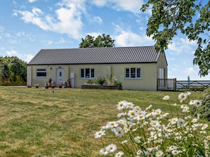 A single-story house with a tiled roof, a front porch, and a well-maintained lawn. - 2 Bed in Beaworthy (oc-52087) (Virginstowe)