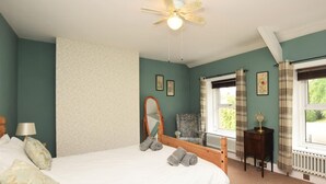 A bedroom with a bed, a chair, a table, a radiator, and a window. - 3 Bed in Wylam (oc-51738) (Wylam)