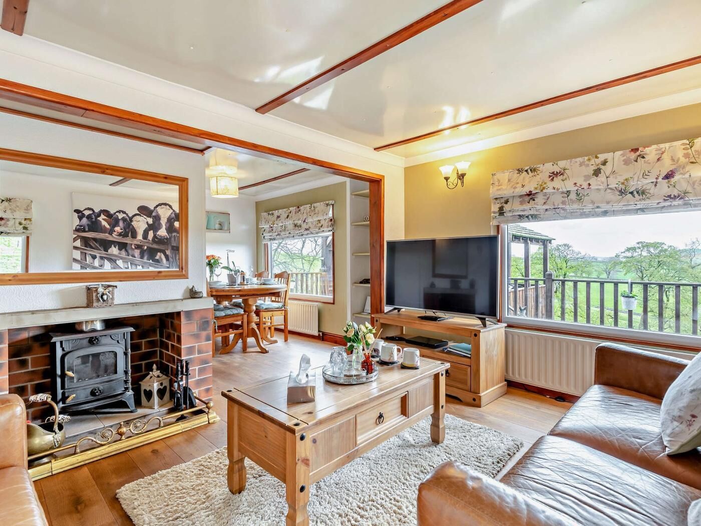 A cozy living room with a fireplace, a television, and a dining area with a view.