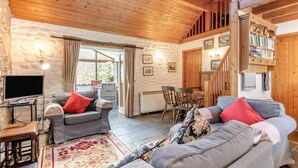 Ein gemütliches Wohnzimmer mit Kamin, Fernseher und einem Essbereich mit Stühlen und Tisch.