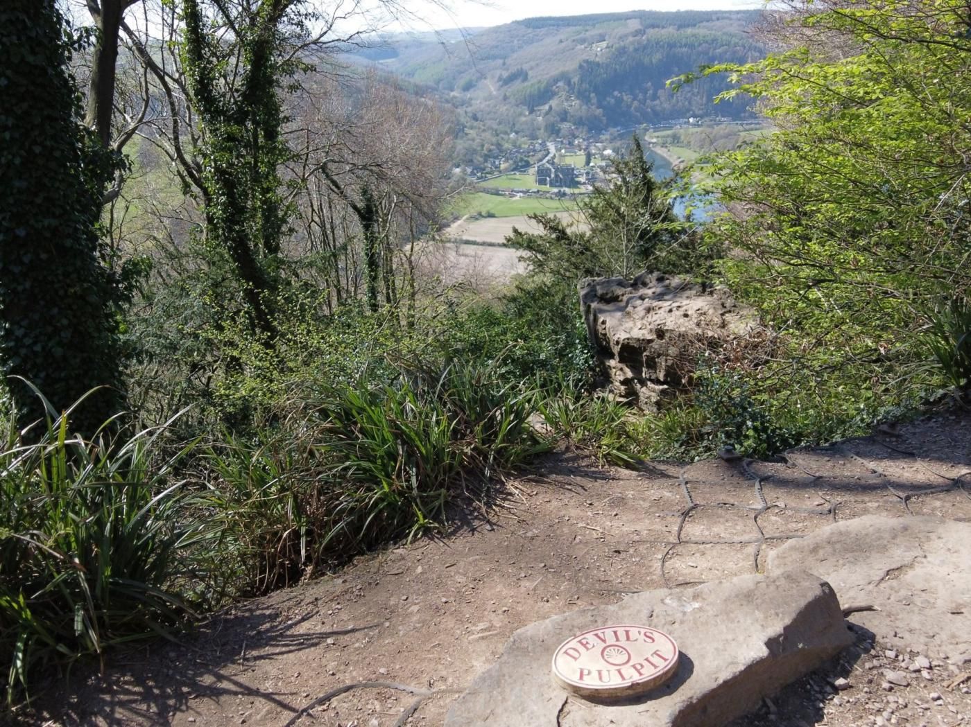 Un camí de terra que condueix a una construcció de pedra amb una placa que diu 'Devil's Pulpit'.