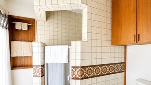 Une salle de bain avec une douche, des toilettes et un porte-serviettes.