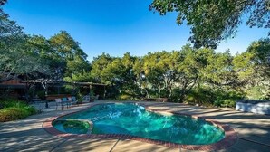 A swimming pool with a brick border, surrounded by a patio area with lounge chairs and a pergola. - 14-Acre Estate with Private Pool near Pismo Beach (San Luis Obispo)