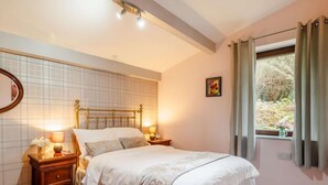 Una camera da letto con un letto, comodini, uno specchio, una finestra con tende e una parete con motivo a griglia.