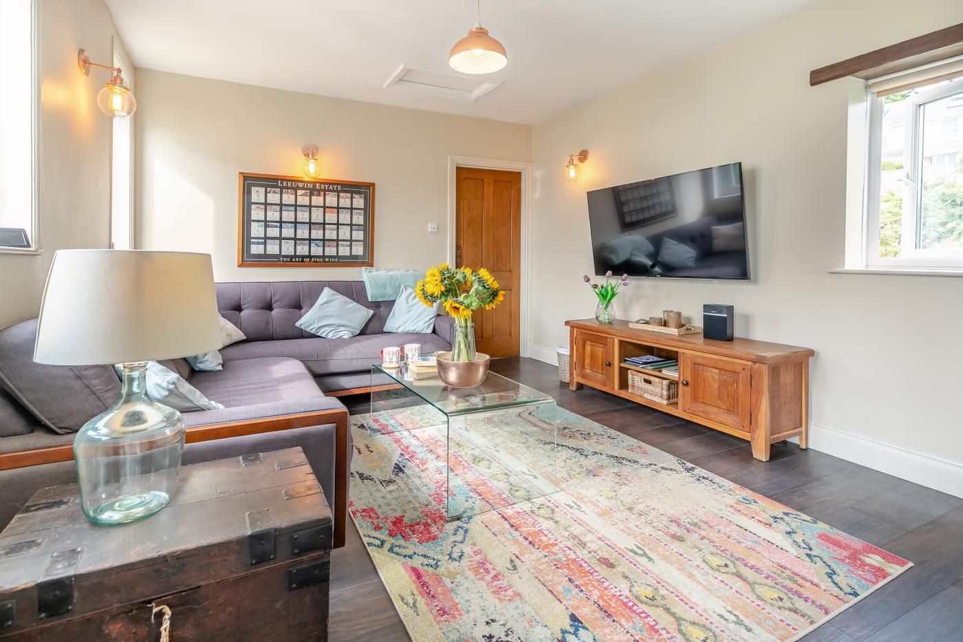 A modern living room with a sofa, coffee table, TV, and a decorative rug.