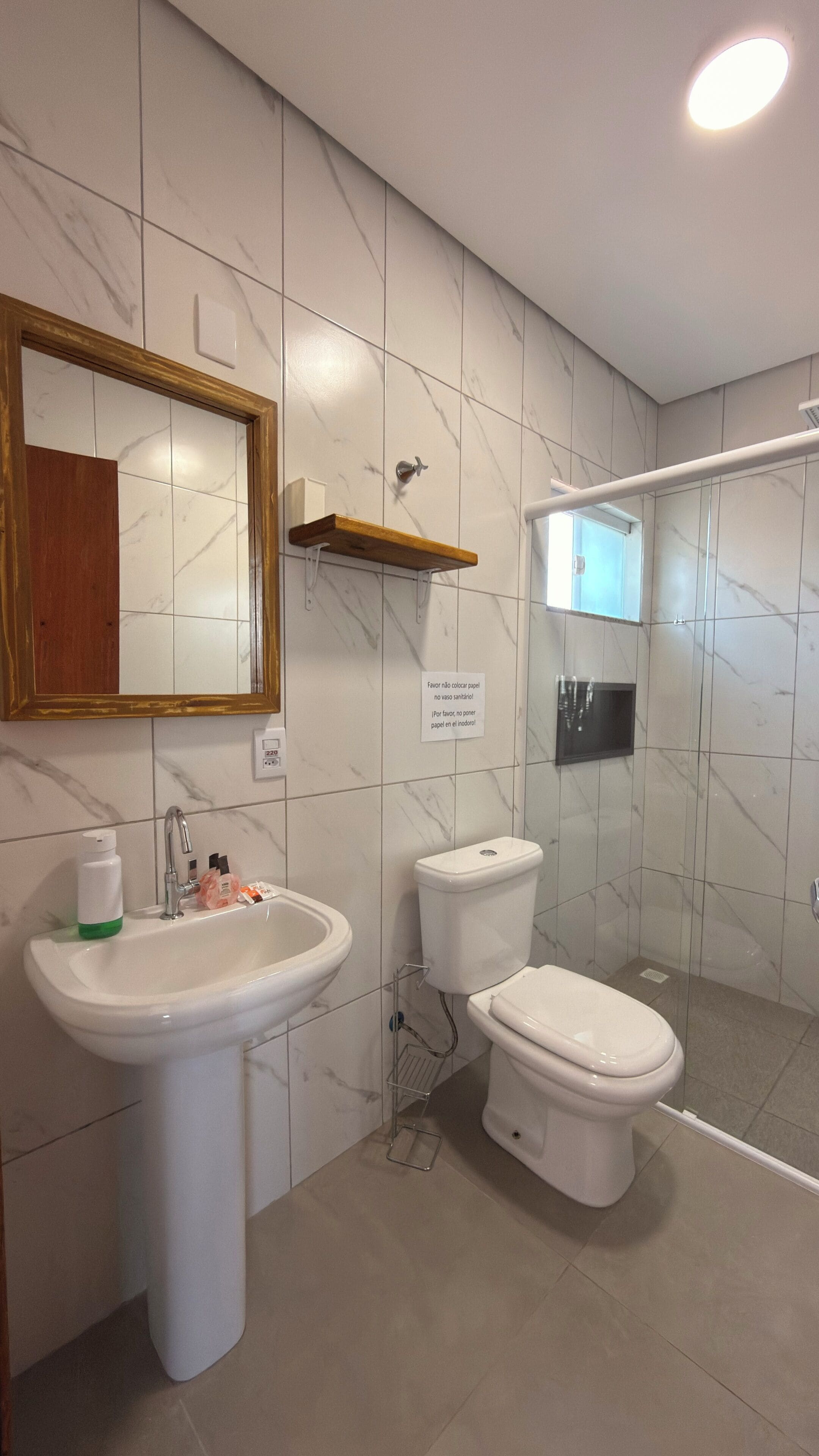 Une salle de bain avec un lavabo, des toilettes et une douche.