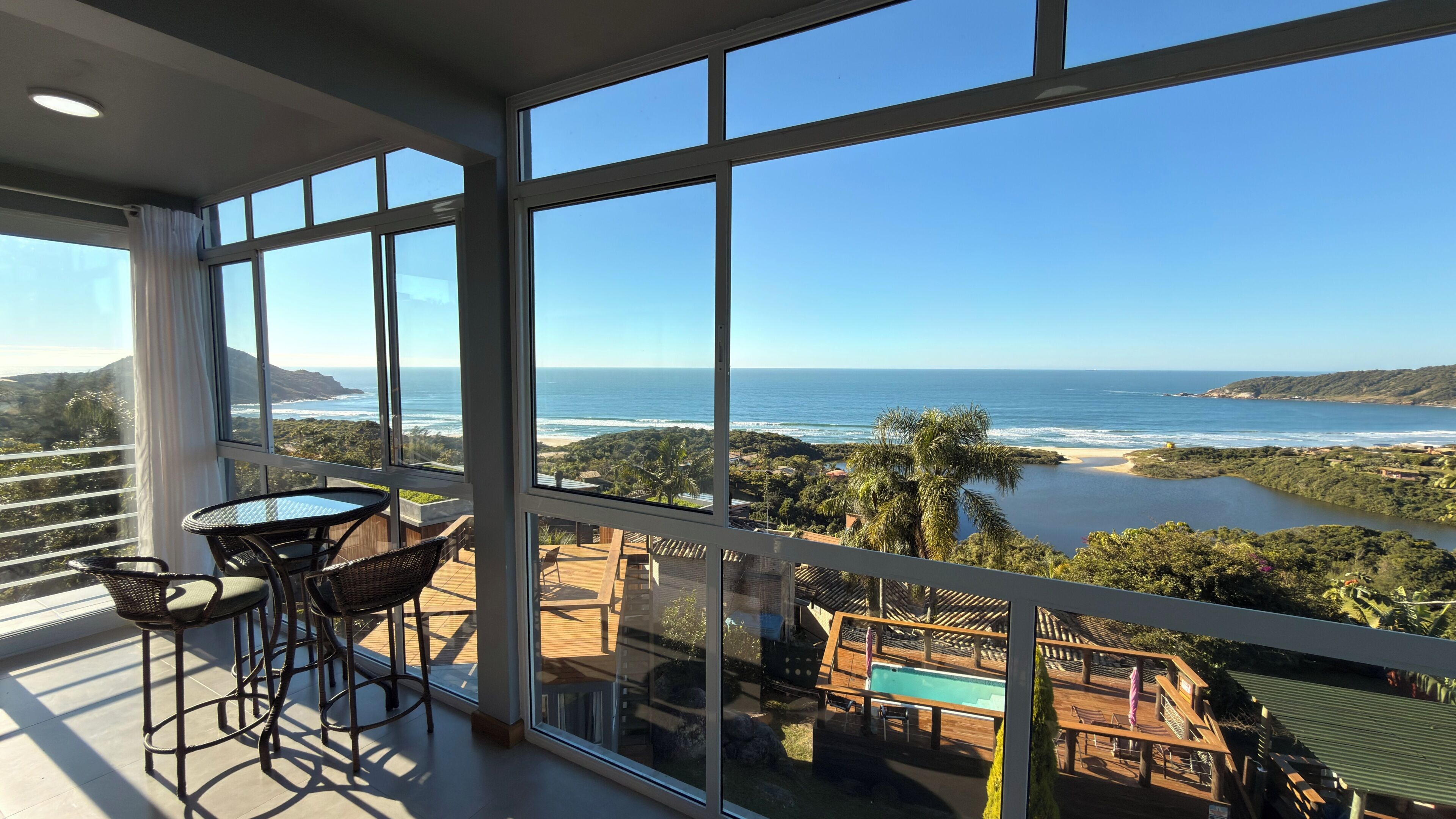 Varanda com vista para o oceano e área de piscina.