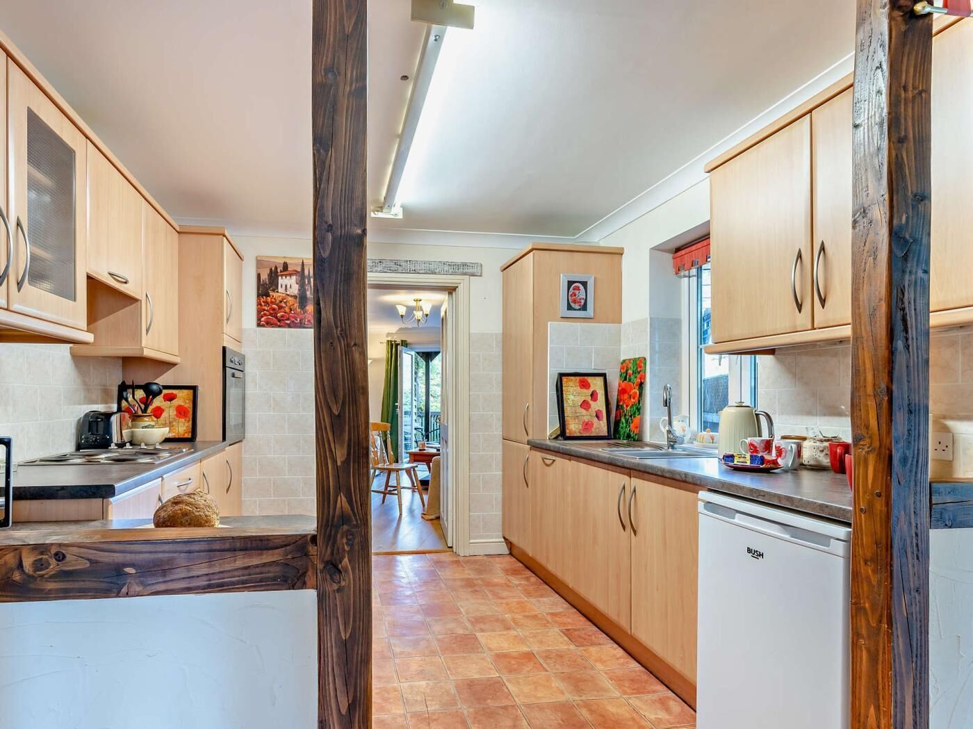 Une cuisine avec des meubles de rangement en bois, un plan de travail, un évier et un lave-vaisselle.