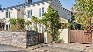 A two-story house with a stone wall, a wooden gate, and a paved driveway. - 1 Bed in Abergavenny (oc-52882) (Gilwern)