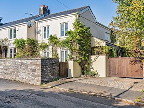 A two-story house with a stone wall, a wooden gate, and a paved driveway. - 1 Bed in Abergavenny (oc-52882) (Gilwern)
