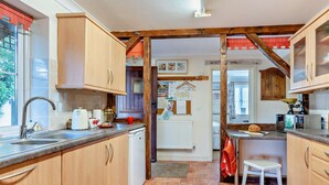 A kitchen with wooden cabinets, a sink, a white refrigerator, and a small white stool. - 1 Bed in Abergavenny (oc-52882) (Gilwern)