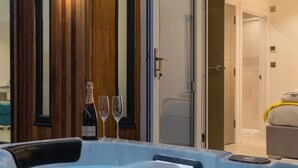 Kylpytynnyri, jonka yhteydessä on pullo Moët-samppanjaa ja kaksi lasia, puupaneloitu seinä ja ovi, joka johtaa kylpyhuoneeseen.