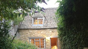 Uma casa de pedra charmosa com uma pequena janela e porta que dá para um interior aconchegante.
