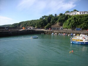 A harbor with boats, a pier, and buildings on a hillside. - 1 Bed in Saundersfoot (oc-52744) (Saundersfoot)