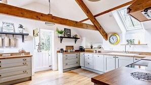 Una cucina con travi in legno, una sveglia e una finestra.