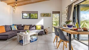 A modern living room with a sectional sofa, a wooden coffee table, and a dining area with a table and chairs. - 1 Bed in Llandrindod Wells (oc-53194) (Llandrindod Wells)