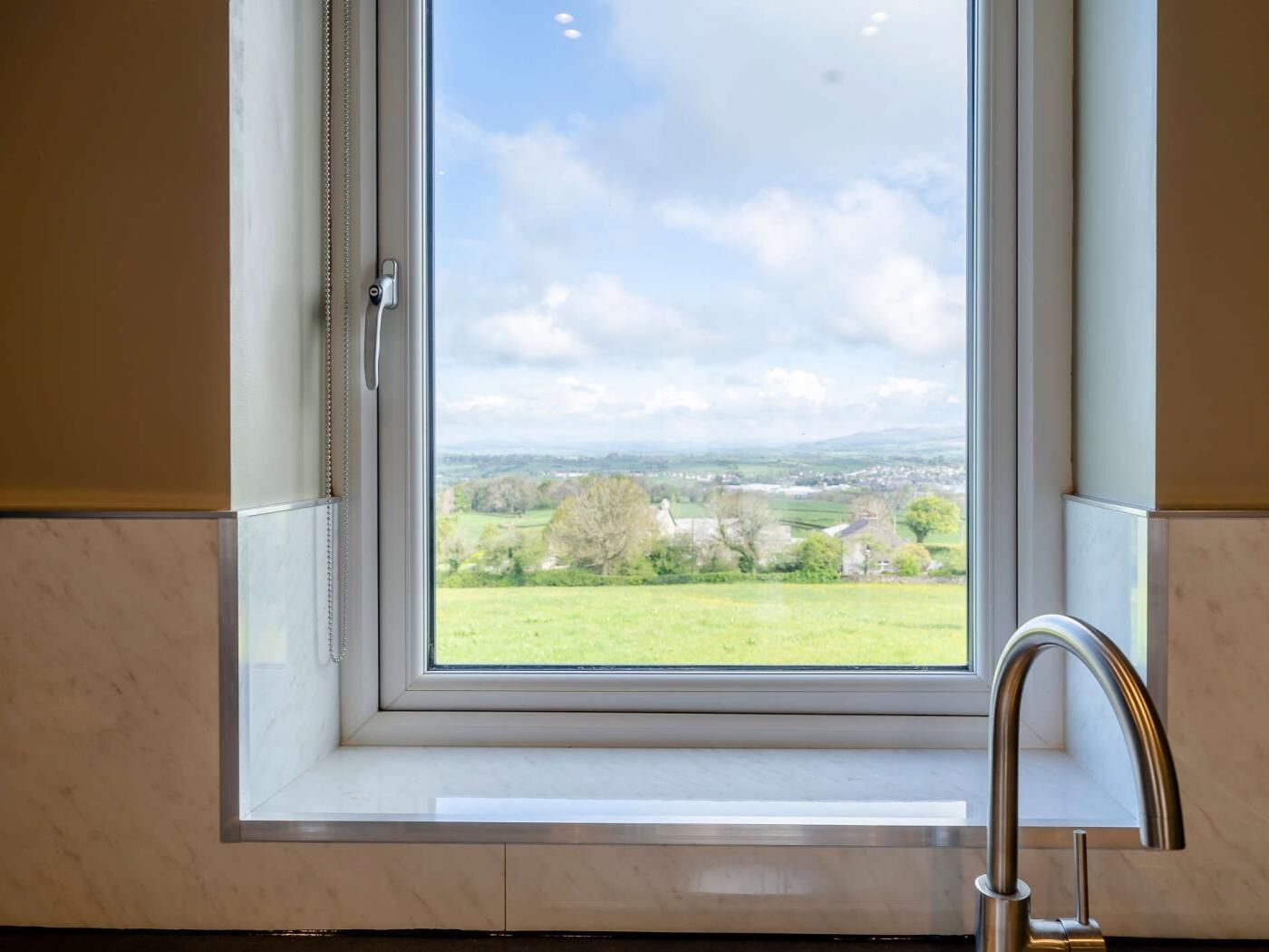 Une salle de bain avec une fenêtre donnant sur un paysage rural.