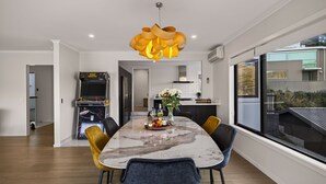 A modern dining area with a marble table, yellow chairs, and a unique pendant light. - Sunrise Retreat - lake and mountain views (Queenstown)