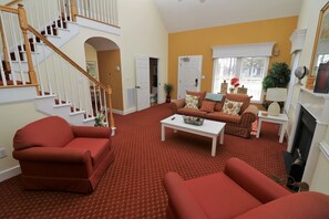 Un salon avec un escalier, une cheminée et une fenêtre donnant sur un beau paysage.