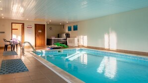 Ein Hallenbad mit Fliesenboden, einer Holztür und einer Rezeption.