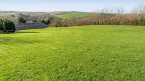 Ein grasbewachsenes Feld mit einem Gebäude in der Ferne.