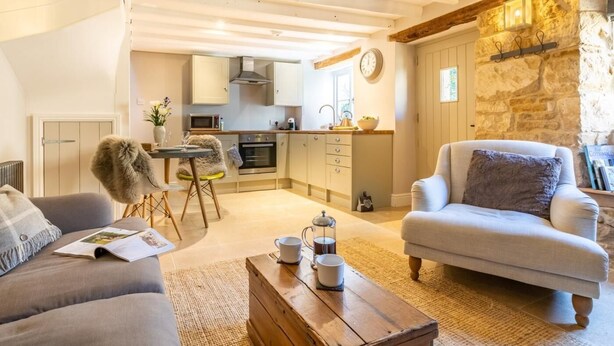 En hyggelig stue med en sofa, et sofabord og et spiseområde med en stol og et bord.