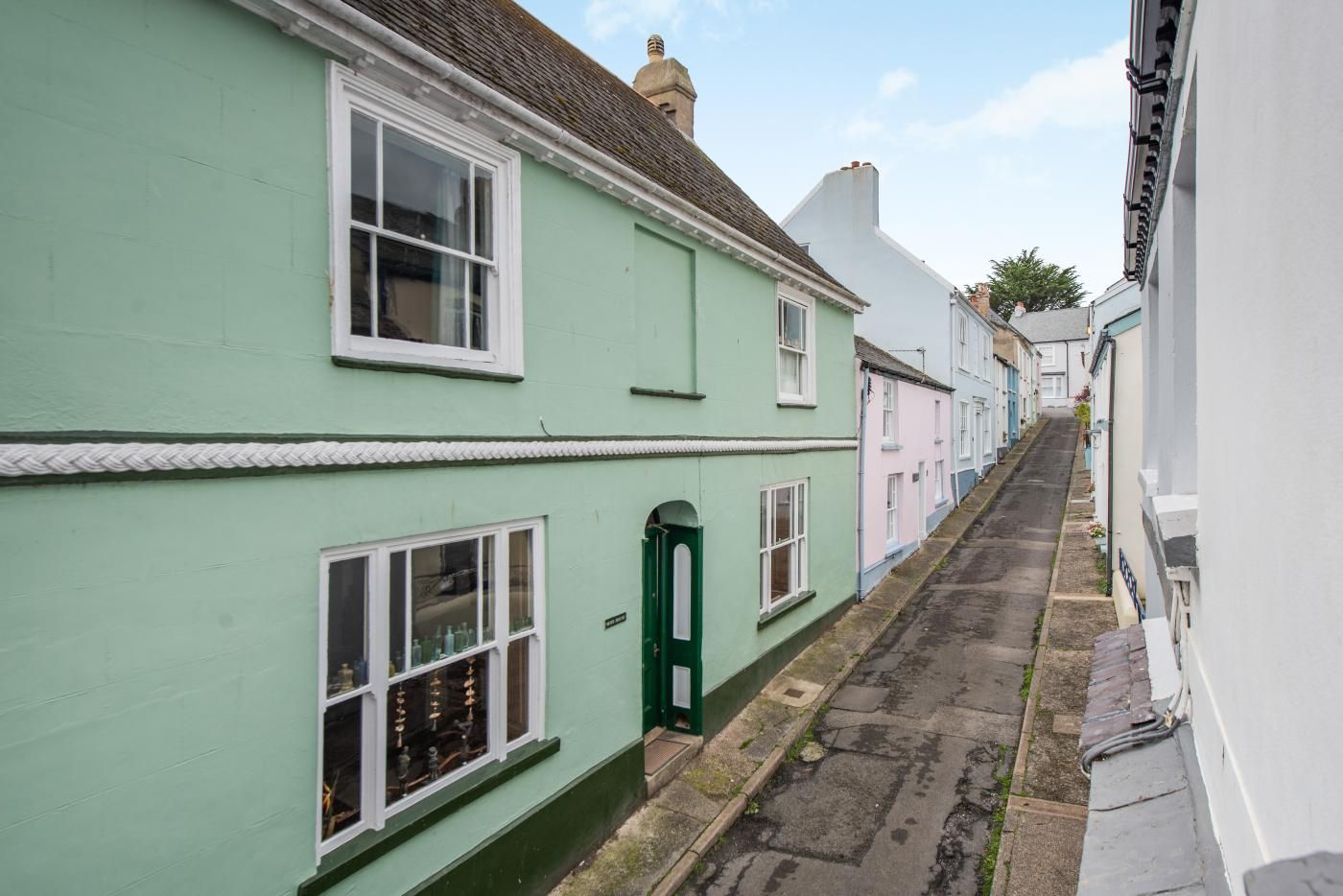 A narrow street lined with traditional buildings, featuring a mix of residential and commercial properties.
