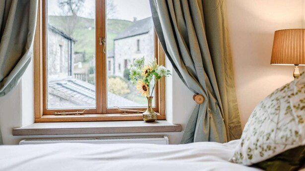 Une chambre avec une fenêtre, un radiateur, une lampe et un lit.