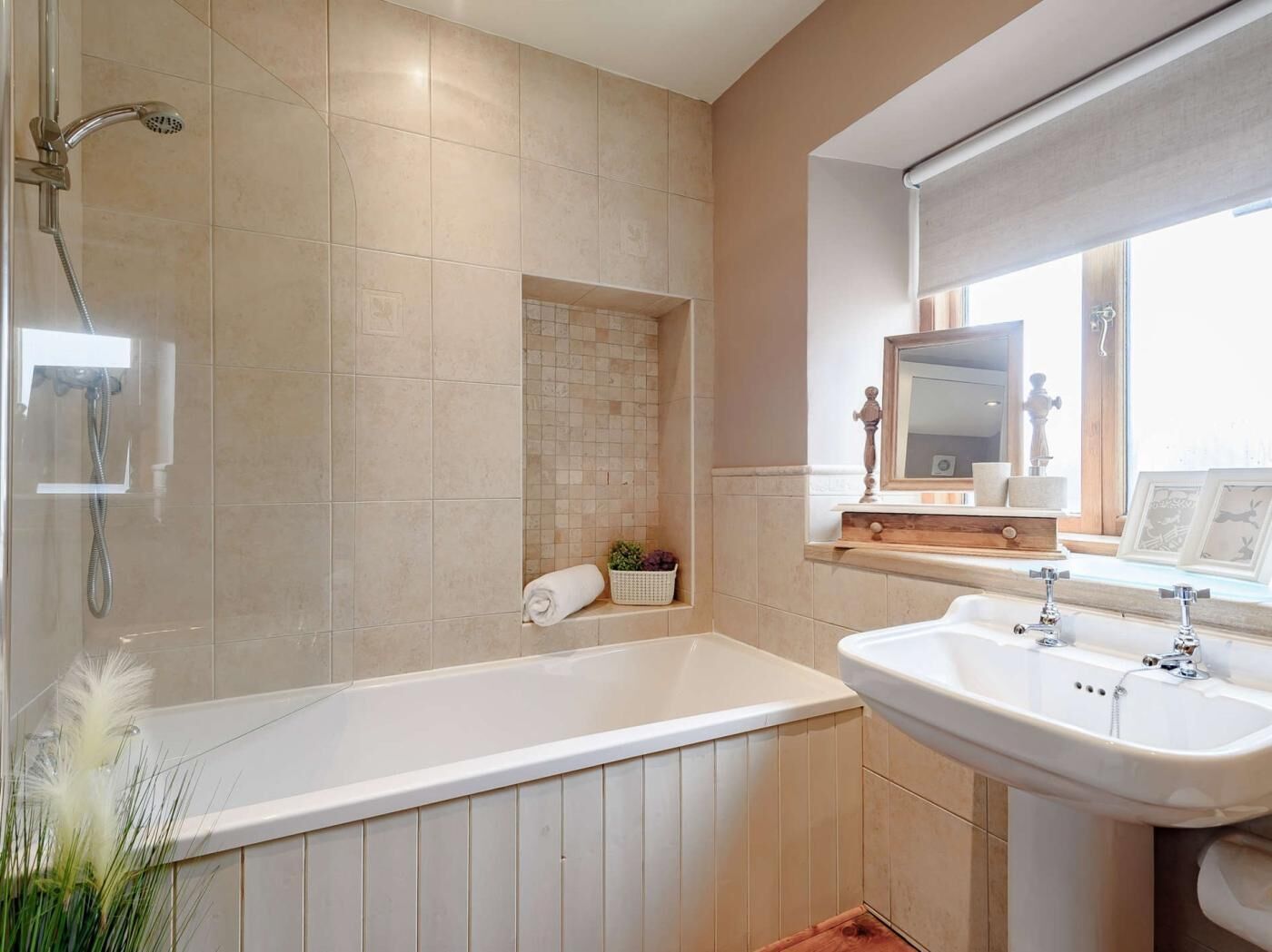 Een moderne badkamer met een badkuip, douche en wastafel.