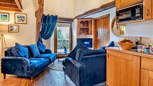 Ein gemütliches Wohnzimmer mit einem blauen Sofa, Holzschränken und einem Fernseher.